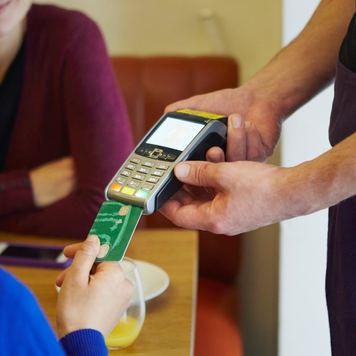 Cropped shot of woman inserting card into credit card machine in restaurant