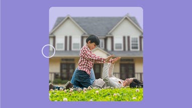 A woman plays with a child on the lawn in front of a white, two-story house. The image has a purple border.