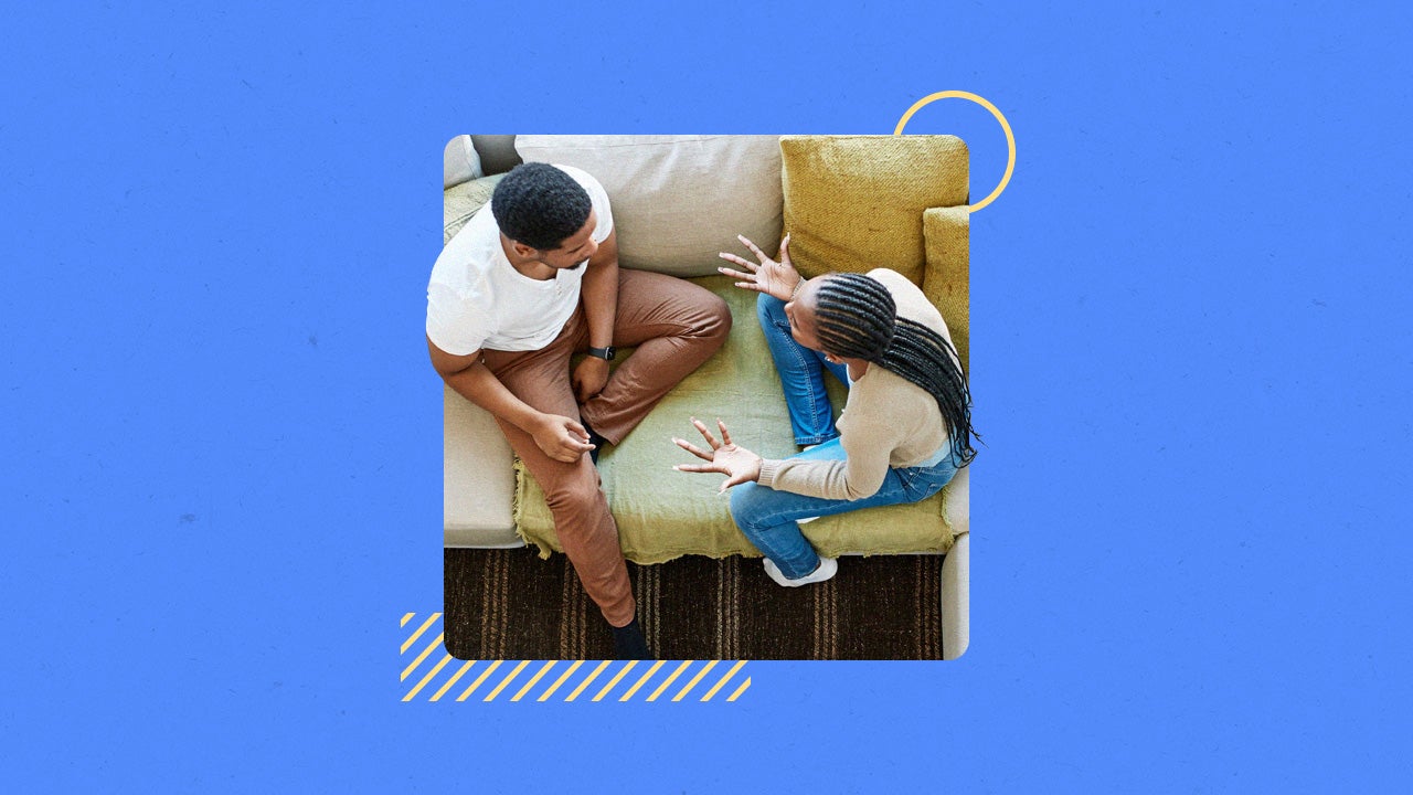 A couple sitting on a couch together, discussing an issue