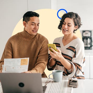A couple standing in front of a laptop