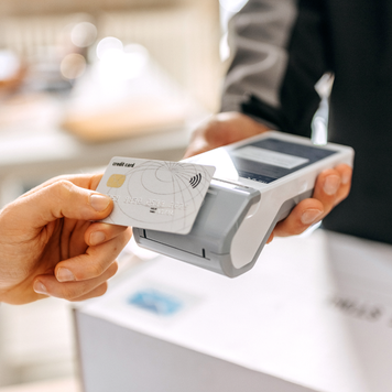 Close up of a man's hand paying delivery with credit card in a office, scanning on a card machine