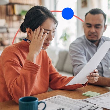 A couple reviewing documents, grimacing