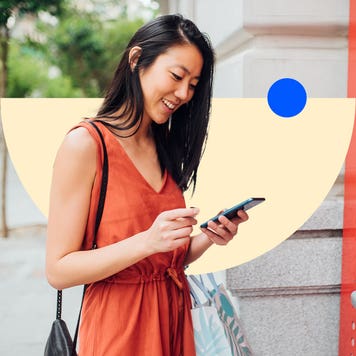 Woman using a cellphone near an ATM