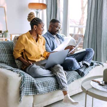 Young smiling couple working from home, going over paperwork