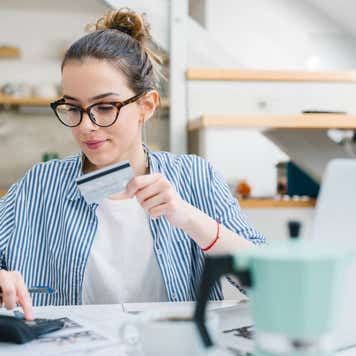 oung woman paying bills/ shopping online with credit card