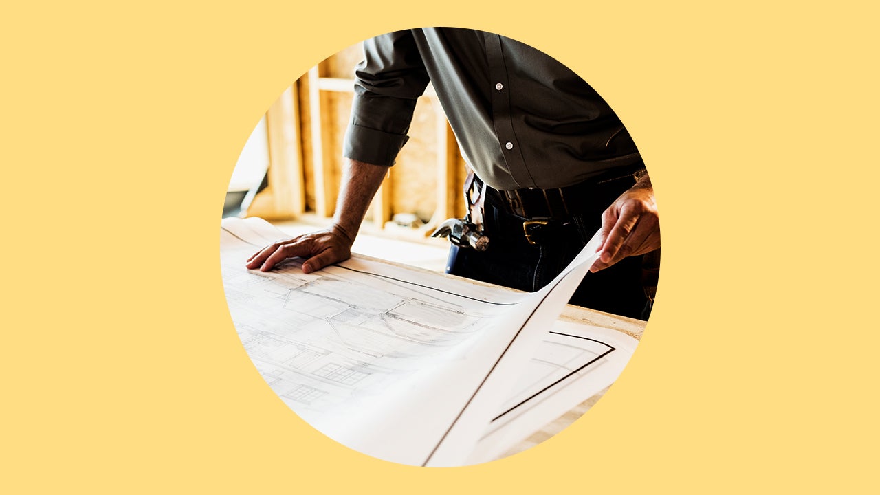 man looking at architectural floor plan of a house