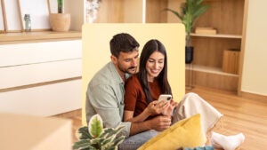 a male-female couple looking at home listings together on a cell phone