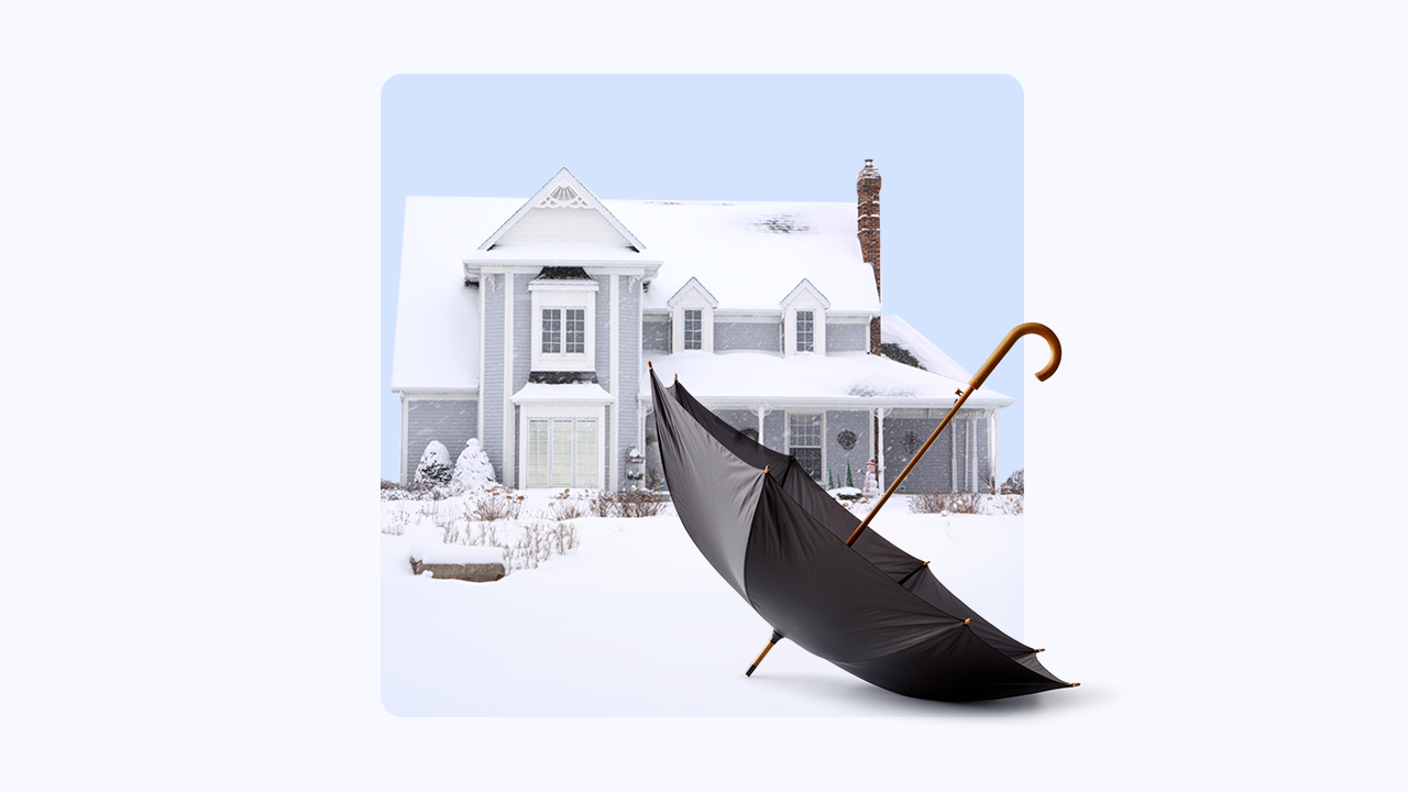 home with snow-covered roof in background, umbrella in foreground