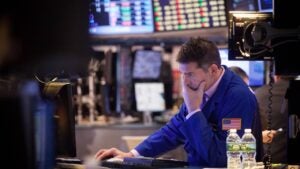 Trader looking at a screen on the floor of an exchange.