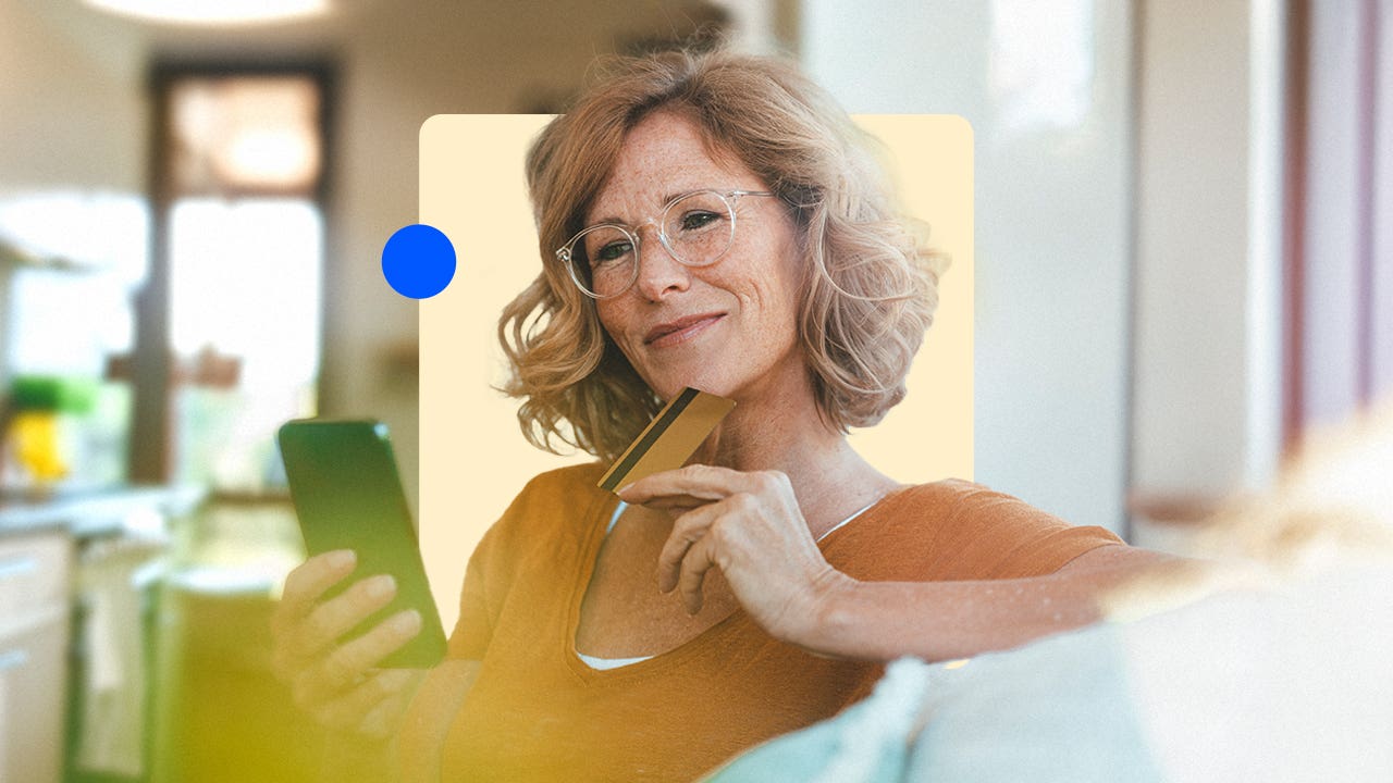 Woman holding a credit card and looking at her phone