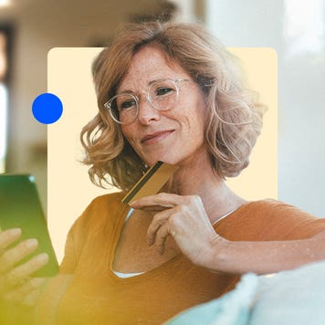 Woman holding a credit card and looking at her phone