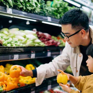 Asian father and daughter shopping at grocery story