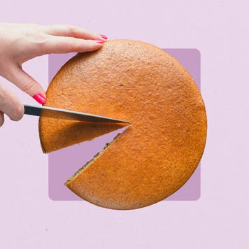 A hand cutting a slice of cake