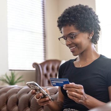 A young woman paying using her credit card on her phone
