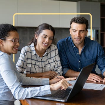 Three people reviewing a laptop together