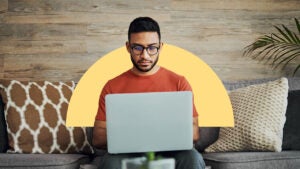 Man works on laptop. Behind him is an image of a yellow half circle overlaid on the photograph's background.