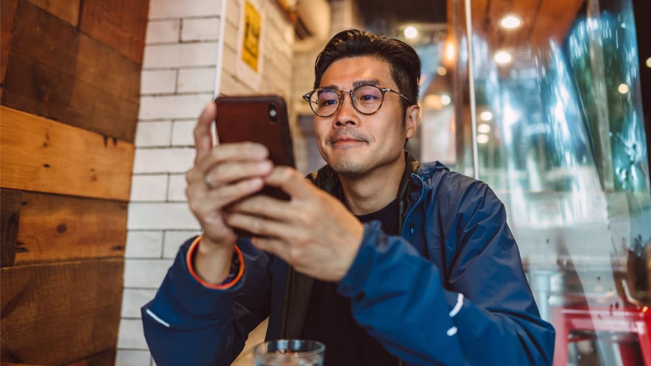 A man looks at his brokerage account on his phone.