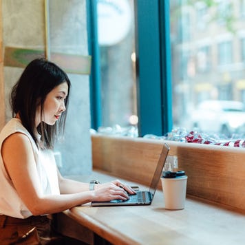 Woman on laptop in cafe.