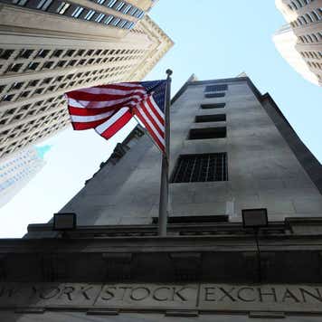 Exterior of the New York Stock Exchange as seen from the ground looking skyward.