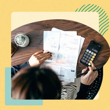 A person with papers in front of them, using a calculator