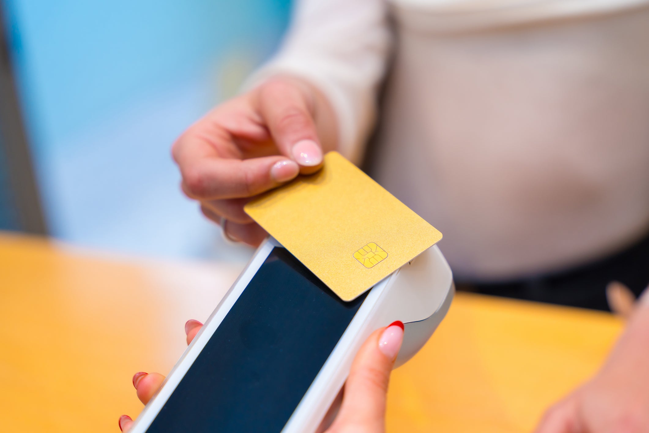 Close-up of a woman paying using credit card in a beautician clinic