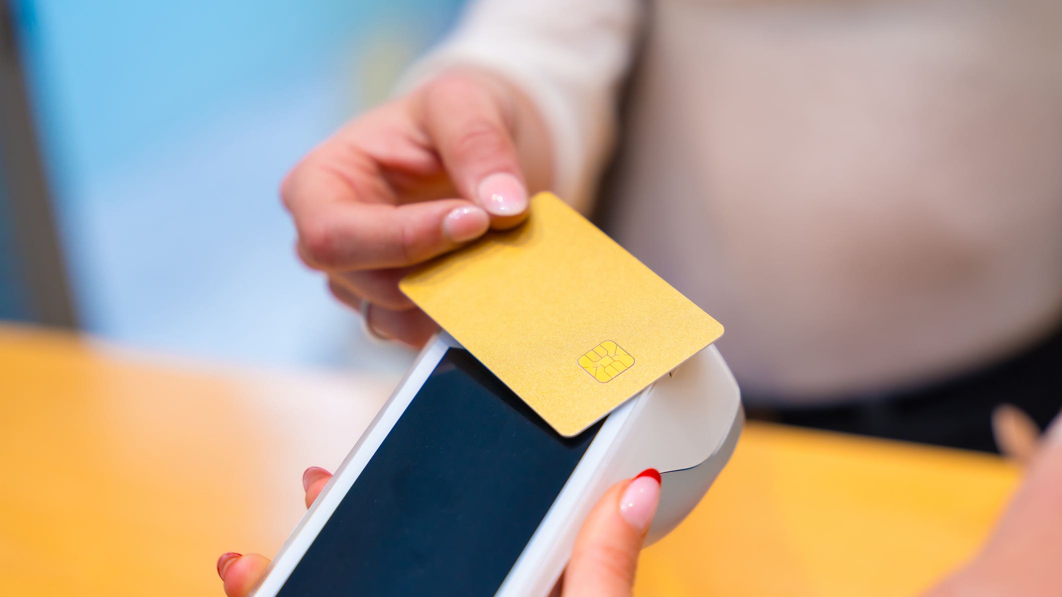 Close-up of a woman paying using credit card in a beautician clinic