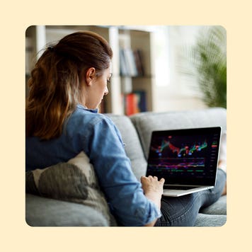 A woman checks her investments on a laptop computer.