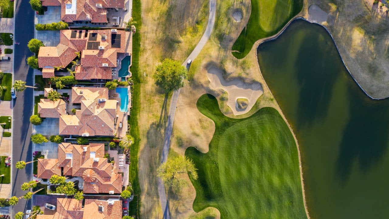 Line of houses next to a golf course.