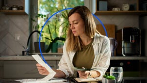 Person sitting at desk looking over bills