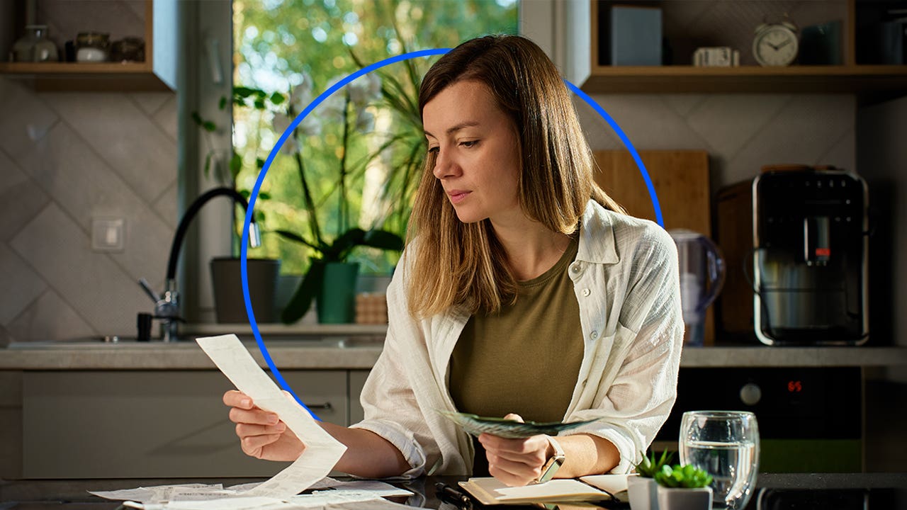 Person sitting at desk looking over bills