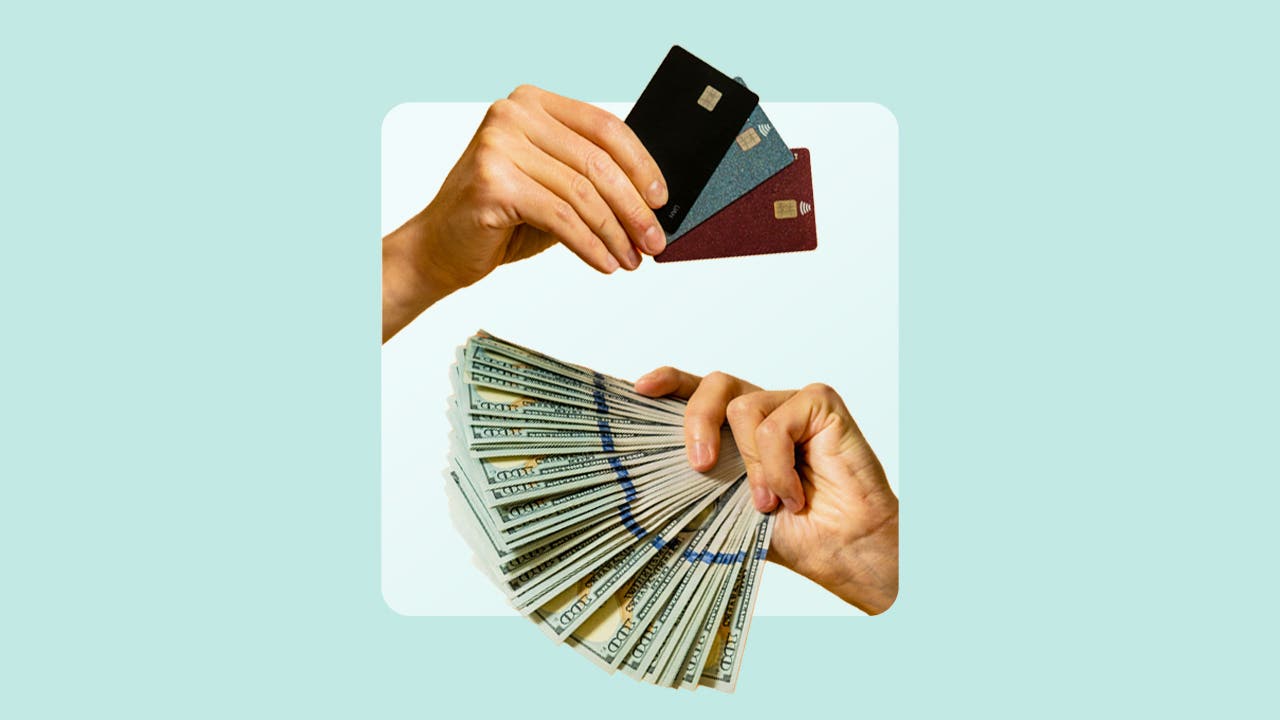 photo of credit cards over a handful of cash both fanned out and held by two different hands