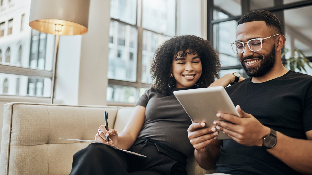 Two people on sofa looking at tablet