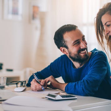 Couple sitting in their living room and checking their finances