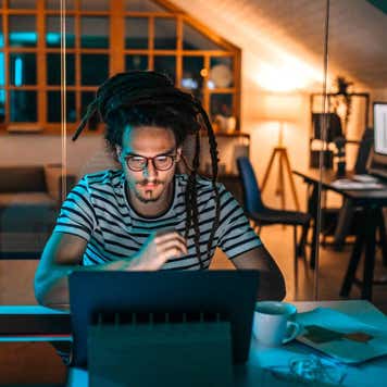 Young man late night working in home office