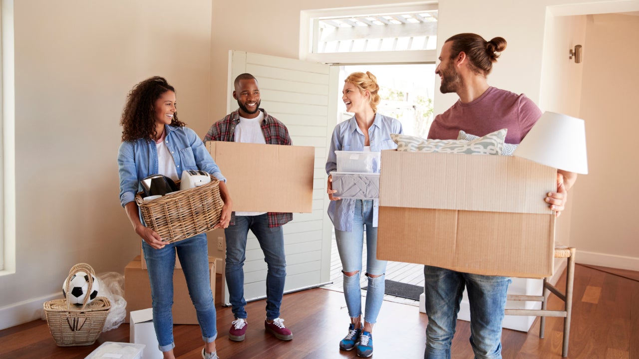 Friends carrying boxes into their new home