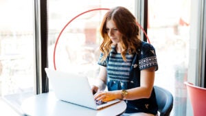 Woman typing on a laptop.