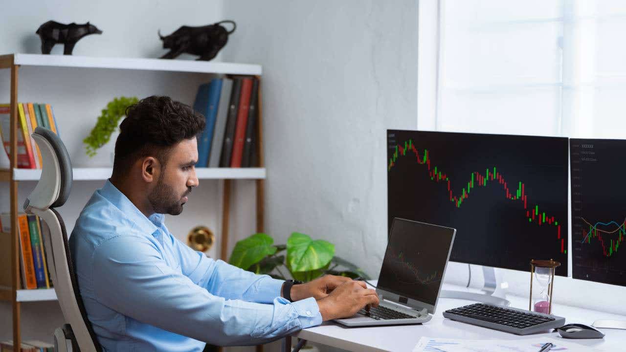 A trader looks at a graph on his computer showing market volatility.
