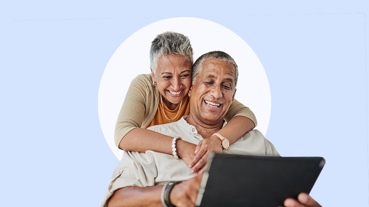 Happy couple looking at a laptop together