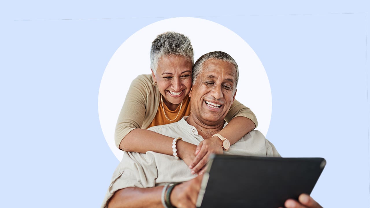 Happy couple looking at a laptop together