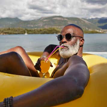 Man drinking juice in inflatable ring