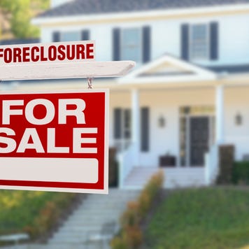 A foreclosure sign in front of a house