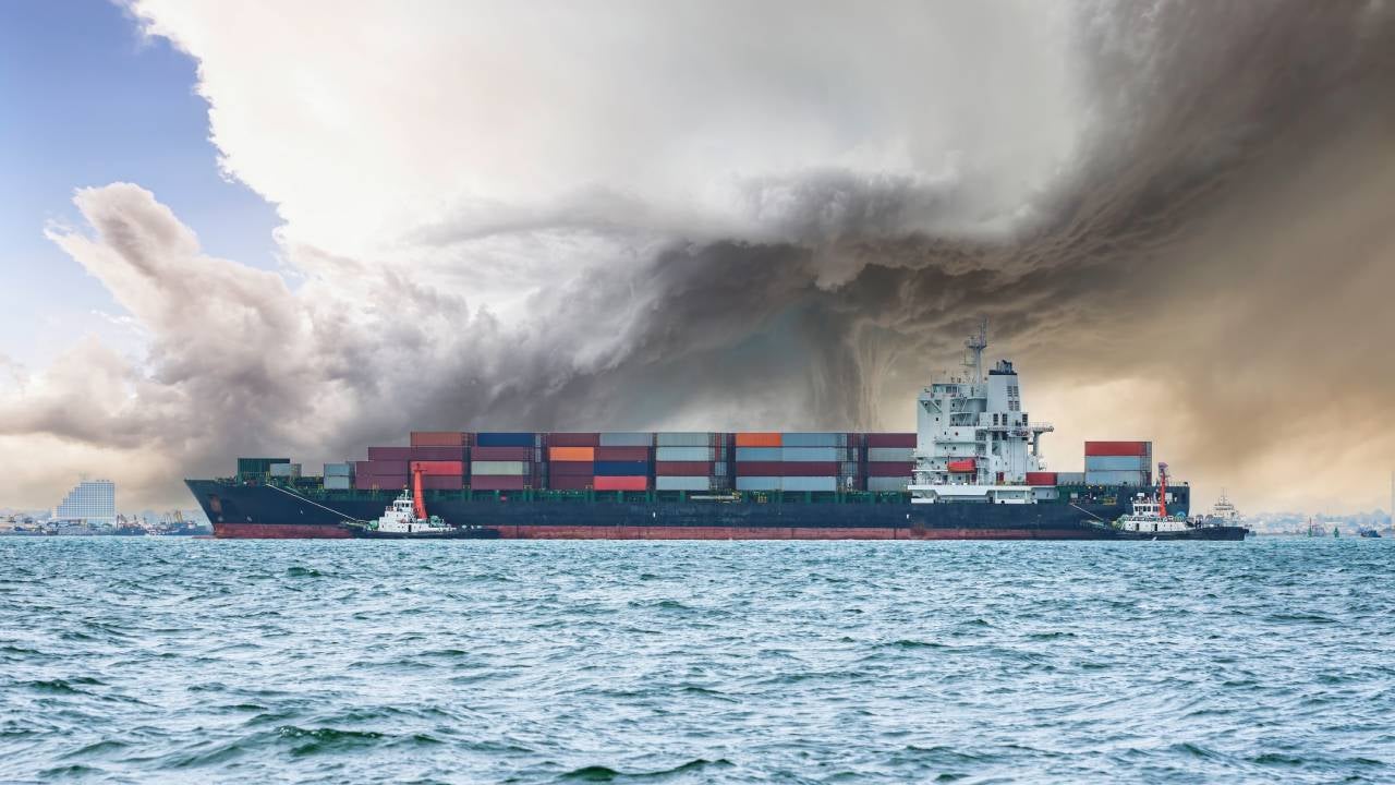 A container ship in choppy seas with storm clouds above.