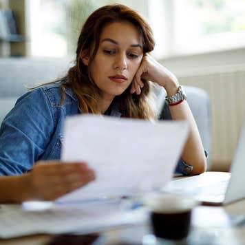 Worried woman about home finances while looking at some documents in front of her laptop
