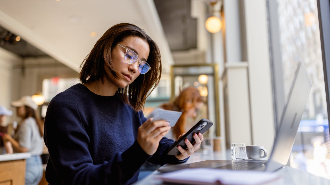 Young Black woman with credit card and a smart phone