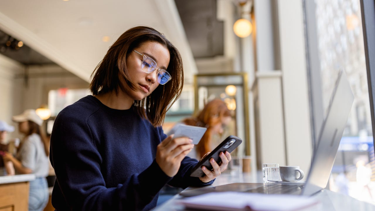 Young Black woman with credit card and a smart phone