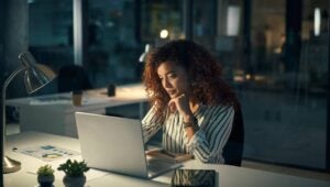 Shot of a young businesswoman using a laptop during a late night at work