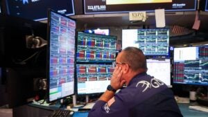 Bond trader looking at multiple monitors.