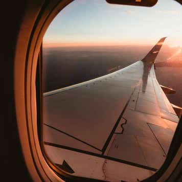 Sunset over California from the window seat of a plane with a sun star