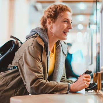 Woman purchasing a train ticket at the railroad station