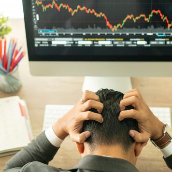 Businessman grabs the head concept with business chart on scoreboard